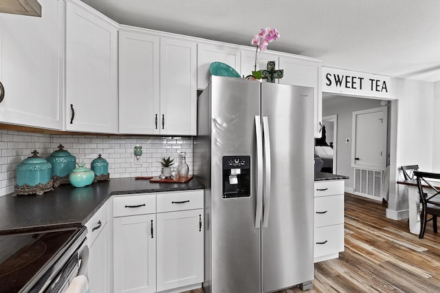 1008 County Road 4759, Sulphur Springs, TX 75482 - kitchen featuring stainless steel fridge with ice dispenser, dark countertops, wood finished floors, tasteful backsplash, and white cabinets