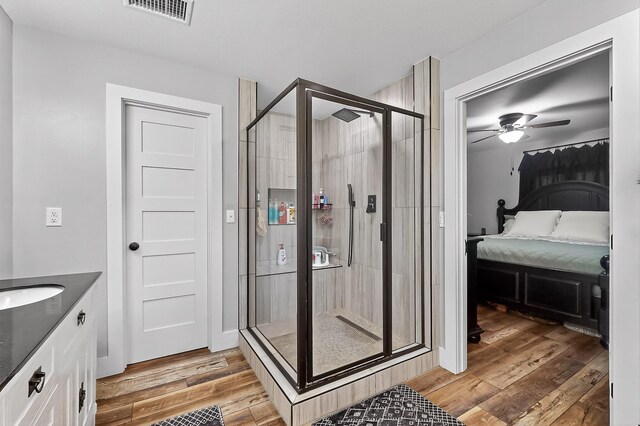 1008 County Road 4759, Sulphur Springs, TX 75482 - ensuite bathroom featuring ceiling fan, a stall shower, vanity, and wood finished floors
