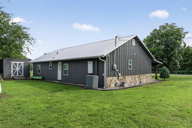 1008 County Road 4759, Sulphur Springs, TX 75482 - rear view of property with board and batten siding, a yard, a storage shed, a metal roof, and stone siding