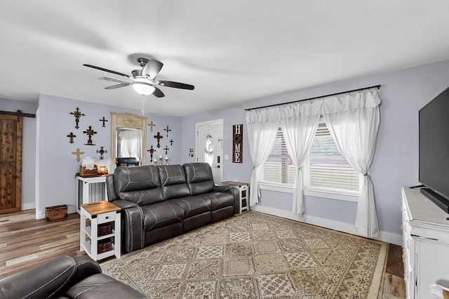 1008 County Road 4759, Sulphur Springs, TX 75482 - living room with a barn door, a ceiling fan, and wood finished floors