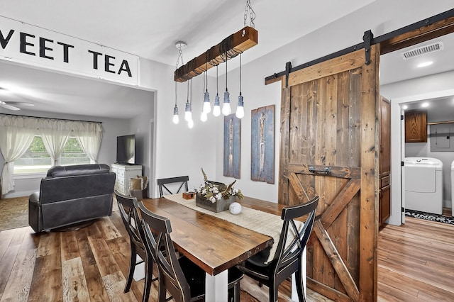 1008 County Road 4759, Sulphur Springs, TX 75482 - dining space with a barn door, hardwood / wood-style floors, and washing machine and clothes dryer