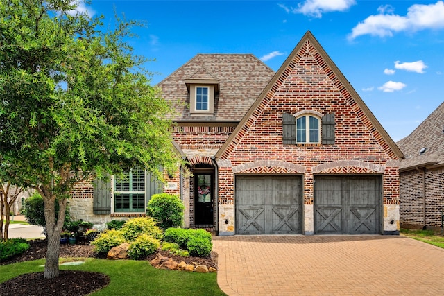 2836 Montreaux, The Colony, TX 75056 - view of front of home featuring brick siding, decorative driveway, an attached garage, and roof with shingles