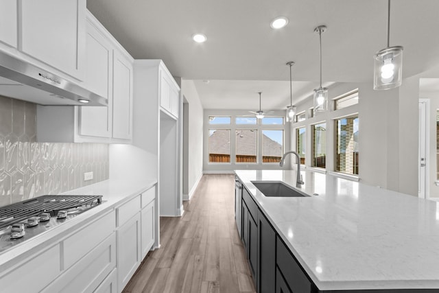 6217 Escarpment Dr, Fort Worth, TX 76112 - kitchen with stainless steel gas stovetop, light wood-type flooring, white cabinetry, under cabinet range hood, and recessed lighting