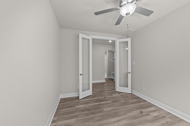 6217 Escarpment Dr, Fort Worth, TX 76112 - unfurnished bedroom featuring french doors, arched walkways, wood finished floors, and ceiling fan