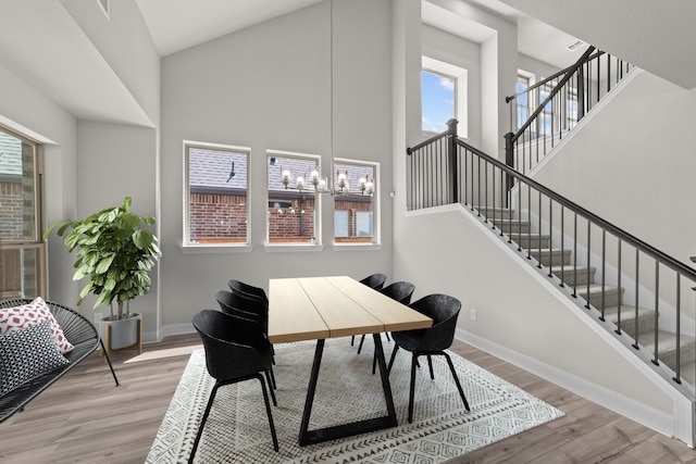 6217 Escarpment Dr, Fort Worth, TX 76112 - dining space with a towering ceiling, wood finished floors, healthy amount of natural light, stairway, and a chandelier