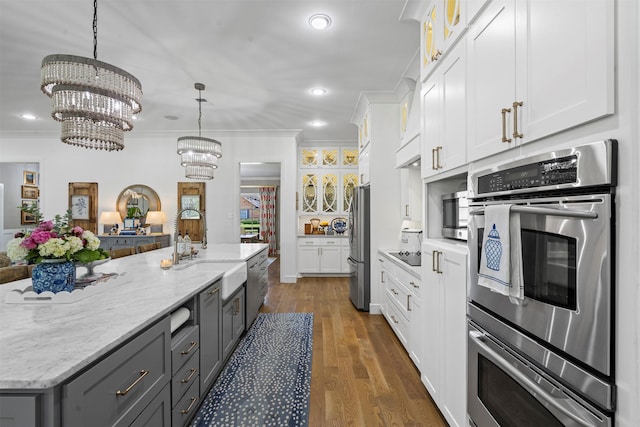 7116 Serrano Dr, Benbrook, TX 76126 - kitchen featuring stainless steel appliances, white cabinetry, a chandelier, ornamental molding, and glass insert cabinets