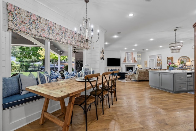 7116 Serrano Dr, Benbrook, TX 76126 - dining area featuring a chandelier, light wood-style flooring, a fireplace, recessed lighting, and a ceiling fan