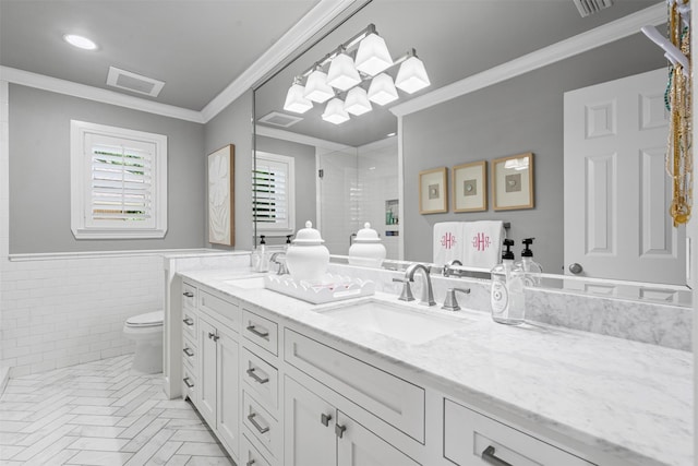7116 Serrano Dr, Benbrook, TX 76126 - full bathroom with double vanity, a stall shower, tile walls, crown molding, and a wainscoted wall