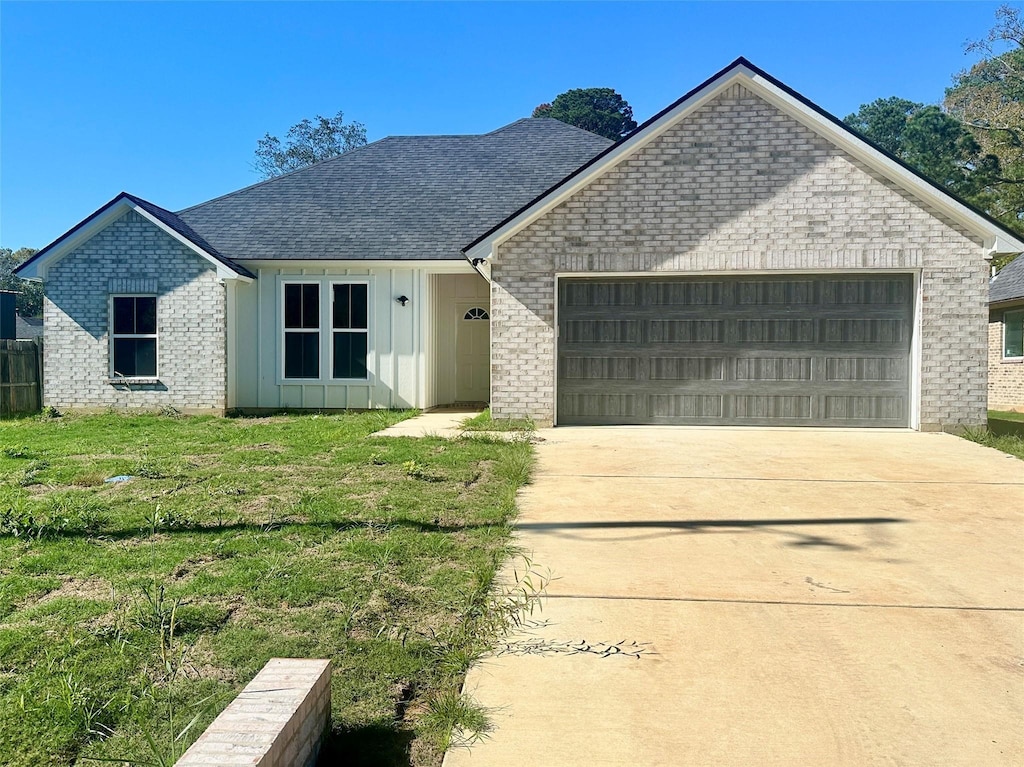 168 Katie Cir, Blanchard, LA 71107 - view of front of house with board and batten siding, brick siding, an attached garage, and driveway