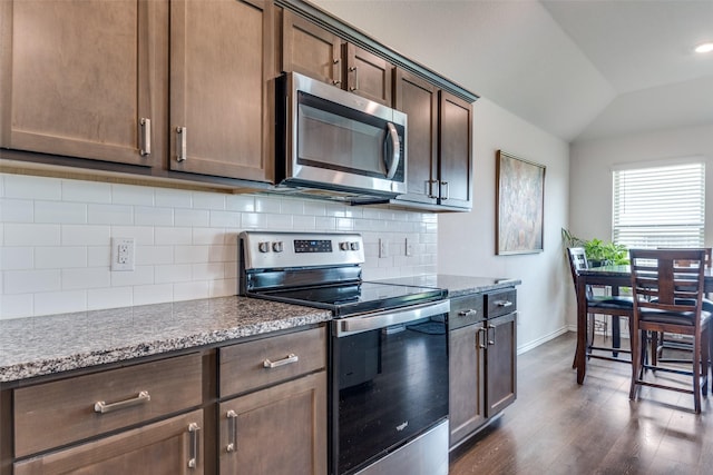 4319 Pyramid Dr, Forney, TX 75126 - kitchen with appliances with stainless steel finishes, vaulted ceiling, dark wood-style flooring, tasteful backsplash, and dark brown cabinets