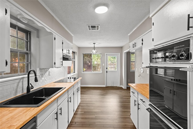 9709 Monticello Dr, Shreveport, LA 71118 - kitchen with black appliances, a textured ceiling, wooden counters, tasteful backsplash, and under cabinet range hood
