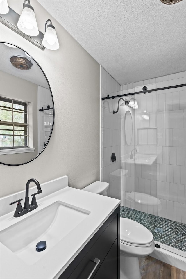 9709 Monticello Dr, Shreveport, LA 71118 - bathroom with a textured ceiling, a stall shower, vanity, and wood finished floors