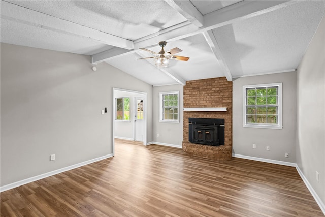 9709 Monticello Dr, Shreveport, LA 71118 - unfurnished living room featuring ceiling fan, wood finished floors, plenty of natural light, a textured ceiling, and a fireplace