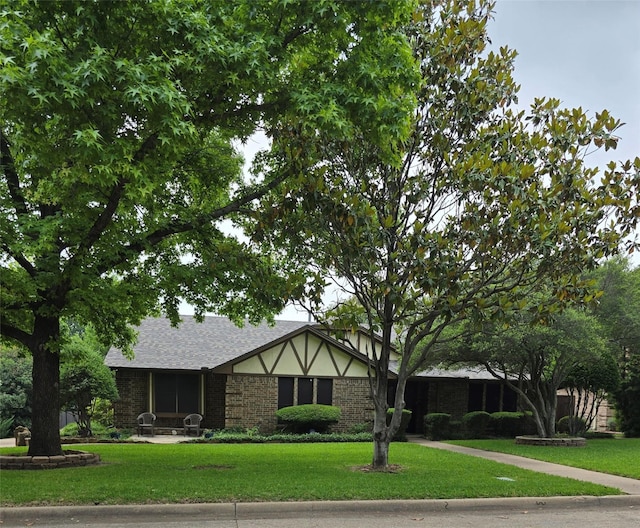 3810 Lucena Ct, Grand Prairie, TX 75052 - tudor-style house featuring a front yard, brick siding, and a shingled roof