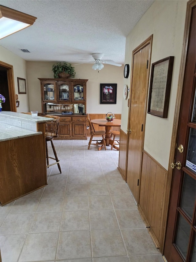3810 Lucena Ct, Grand Prairie, TX 75052 - hall featuring wainscoting, a textured ceiling, wood walls, and light tile patterned floors