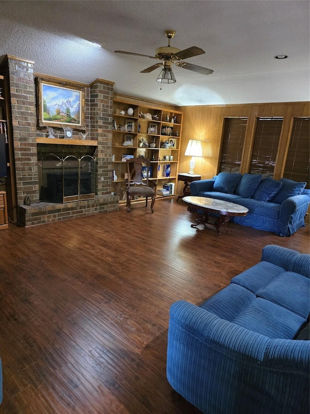 3810 Lucena Ct, Grand Prairie, TX 75052 - living room featuring wood finished floors, a brick fireplace, ceiling fan, a textured ceiling, and wooden walls