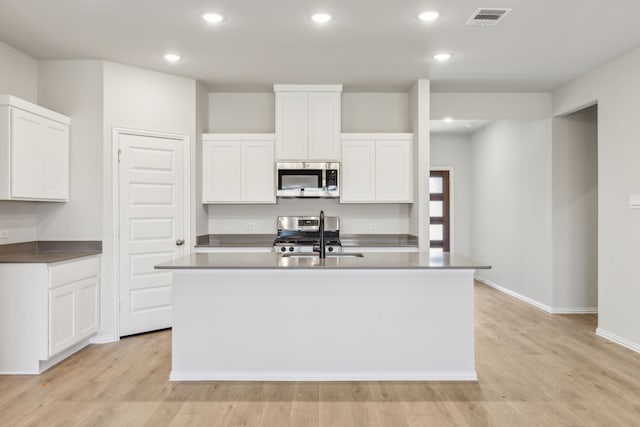 535 Forest Hvn, Van Alstyne, TX 75495 - kitchen with appliances with stainless steel finishes, a kitchen island with sink, light wood finished floors, recessed lighting, and white cabinetry