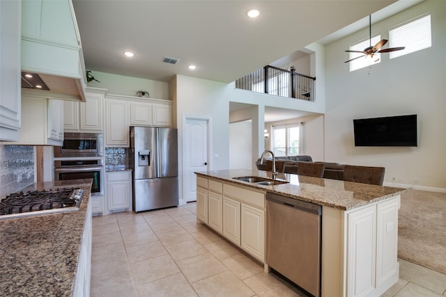 11100 Tanager Ln, Cross Roads, TX 76227 - kitchen with stainless steel appliances, open floor plan, a ceiling fan, backsplash, and light stone counters