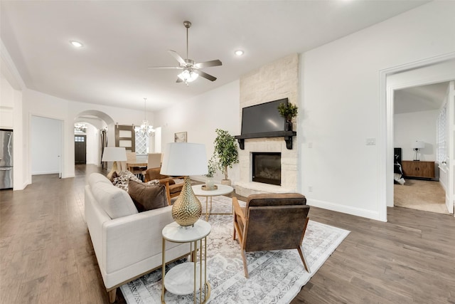 10800 Runner Oak Rd, Flower Mound, TX 76226 - living area featuring ceiling fan, arched walkways, a stone fireplace, a chandelier, and wood finished floors