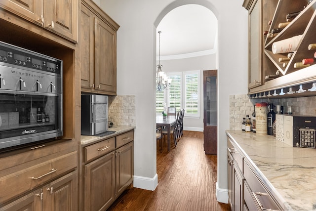 1707 Ponderosa Trl, Sachse, TX 75048 - kitchen featuring ornamental molding, a chandelier, dark wood finished floors, tasteful backsplash, and light stone countertops