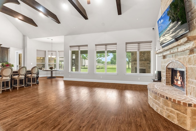 1707 Ponderosa Trl, Sachse, TX 75048 - living area with high vaulted ceiling, a fireplace, beamed ceiling, wood finished floors, and ceiling fan