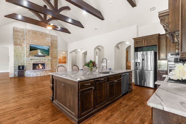 1707 Ponderosa Trl, Sachse, TX 75048 - kitchen featuring appliances with stainless steel finishes, high vaulted ceiling, beamed ceiling, a center island with sink, and dark wood finished floors