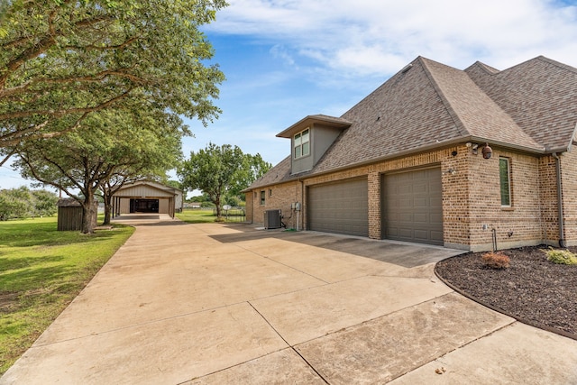 1707 Ponderosa Trl, Sachse, TX 75048 - view of side of home with roof with shingles, brick siding, driveway, a yard, and an attached garage