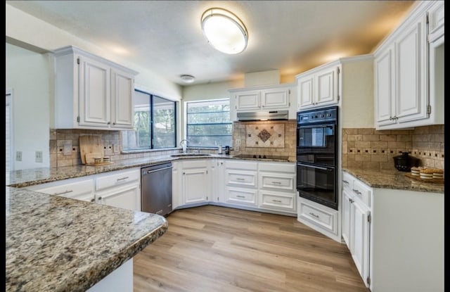 5016 Kemble St, Fort Worth, TX 76103 - kitchen with black appliances, decorative backsplash, white cabinets, and stone counters