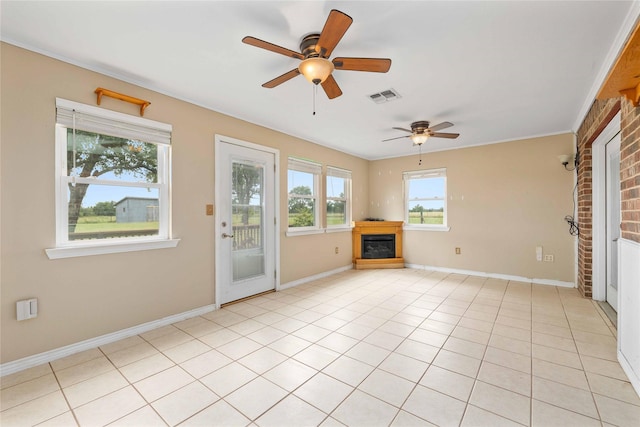 875 Cr221, Stephenville, TX 76401 - unfurnished living room featuring a glass covered fireplace, ceiling fan, and light tile patterned flooring