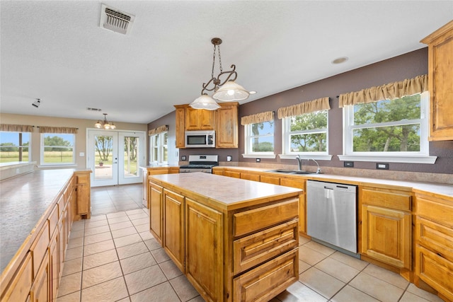875 Cr221, Stephenville, TX 76401 - kitchen with stainless steel appliances, a center island, light tile patterned floors, and light countertops