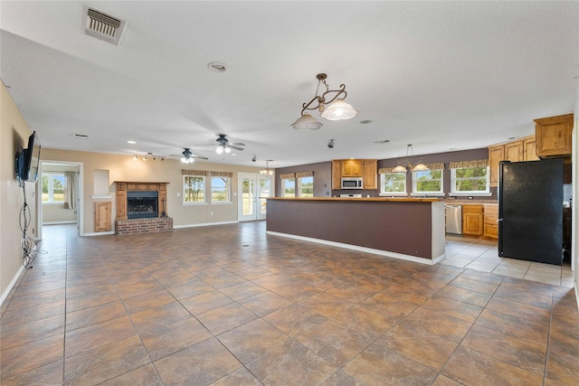 875 Cr221, Stephenville, TX 76401 - unfurnished living room featuring a fireplace, ceiling fan, healthy amount of natural light, tile patterned floors, and recessed lighting