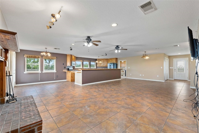 875 Cr221, Stephenville, TX 76401 - unfurnished living room with ceiling fan, recessed lighting, a chandelier, dark tile patterned floors, and track lighting