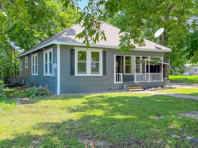 408 S Throckmorton Ave, Kerens, TX 75144 - view of front of home with covered porch, a front lawn, and a shingled roof