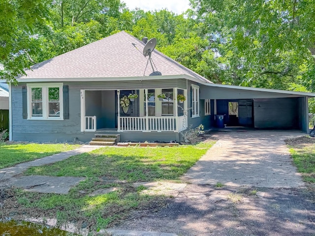 408 S Throckmorton Ave, Kerens, TX 75144 - view of front facade with a porch, driveway, an attached carport, a front lawn, and a shingled roof