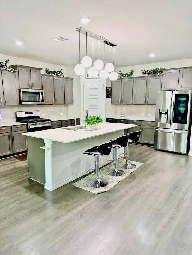 3316 Azure Ln, Celina, TX 75009 - kitchen featuring stainless steel appliances, decorative backsplash, light wood-type flooring, a breakfast bar, and recessed lighting