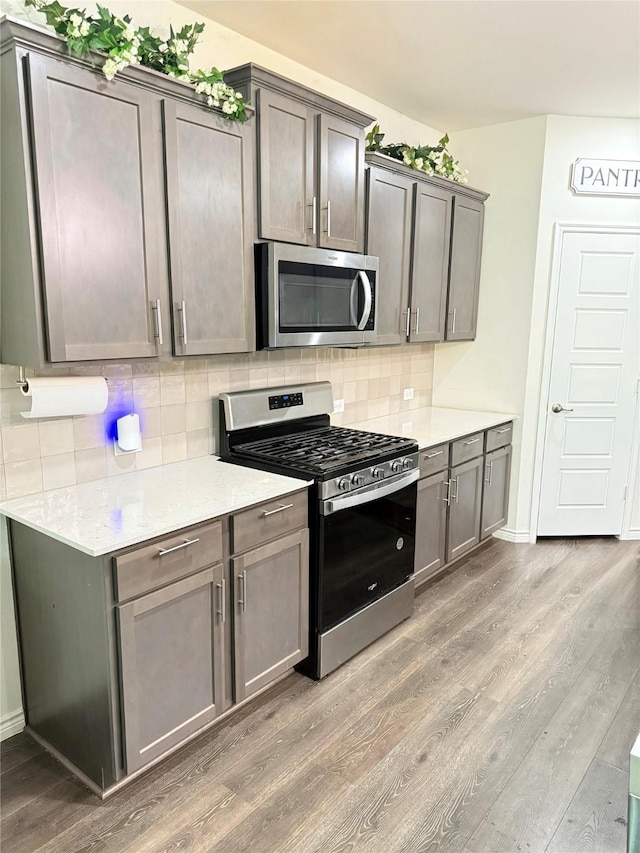 3316 Azure Ln, Celina, TX 75009 - kitchen featuring stainless steel appliances, wood finished floors, and tasteful backsplash