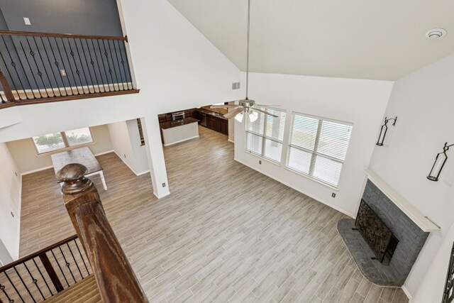 326 Blackhaw Dr, Fate, TX 75087 - living area featuring high vaulted ceiling, a brick fireplace, light wood finished floors, and a ceiling fan
