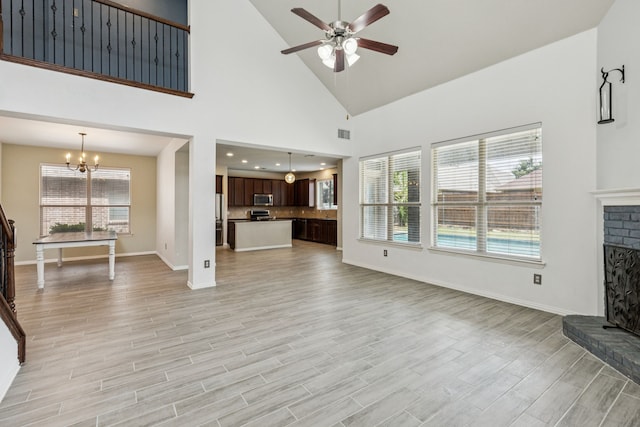 326 Blackhaw Dr, Fate, TX 75087 - unfurnished living room featuring a fireplace, ceiling fan, a chandelier, light wood-style floors, and plenty of natural light