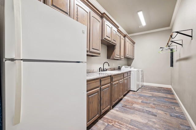 10107 Ravenswood Rd, Granbury, TX 76049 - washroom with ornamental molding, wood finished floors, independent washer and dryer, and cabinet space