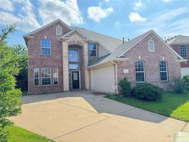 4712 Englishtown Dr, Arlington, TX 76016 - traditional-style house featuring concrete driveway, brick siding, an attached garage, and roof with shingles