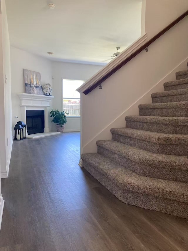 2601 Pinto Dr, Denton, TX 76210 - staircase with wood finished floors, a fireplace with raised hearth, and a ceiling fan