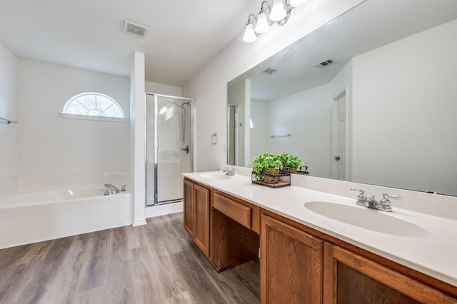 2601 Pinto Dr, Denton, TX 76210 - bathroom with a stall shower, double vanity, a garden tub, and wood finished floors
