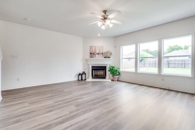 2601 Pinto Dr, Denton, TX 76210 - unfurnished living room with ceiling fan, light wood-style flooring, and a fireplace with raised hearth