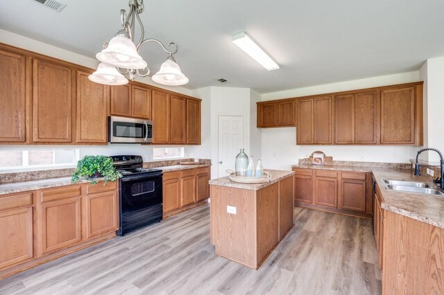 2601 Pinto Dr, Denton, TX 76210 - kitchen featuring stainless steel microwave, black electric range oven, brown cabinets, and light wood-style floors