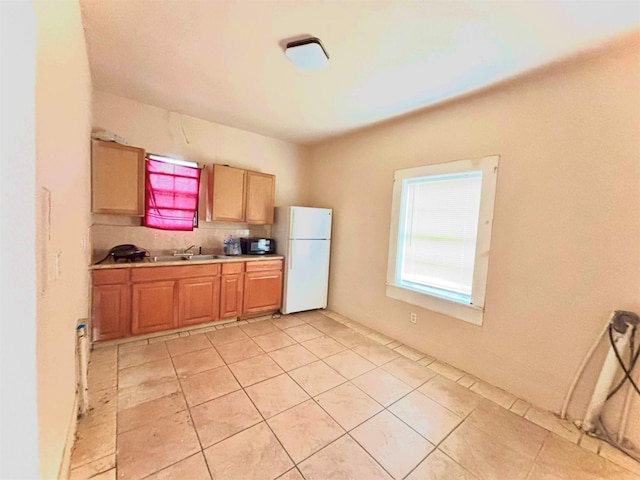 870 SW 4th St, Paris, TX 75460 - kitchen featuring freestanding refrigerator, light countertops, light tile patterned floors, and backsplash