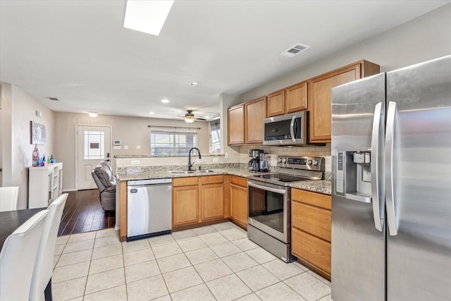 2124 Franks St, Fort Worth, TX 76177 - kitchen with stainless steel appliances, a peninsula, light stone countertops, decorative backsplash, and recessed lighting