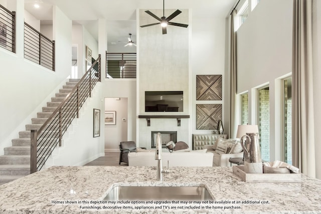 2301 Christopher Rd, Mansfield, TX 76063 - living area with a high ceiling, ceiling fan, stairs, a fireplace, and wood finished floors
