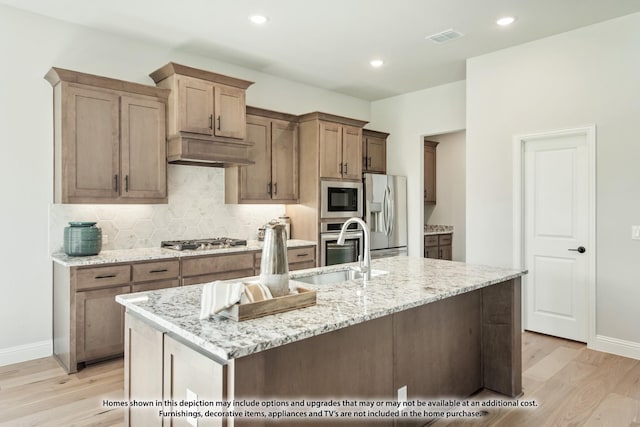 2301 Christopher Rd, Mansfield, TX 76063 - kitchen with stainless steel appliances, light wood-style floors, backsplash, light stone counters, and recessed lighting