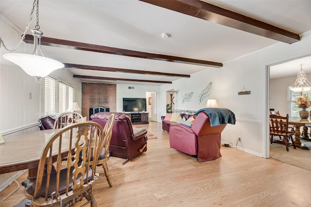 1719 W Day St, Denison, TX 75020 - living room featuring beamed ceiling, healthy amount of natural light, wood finished floors, a chandelier, and a brick fireplace