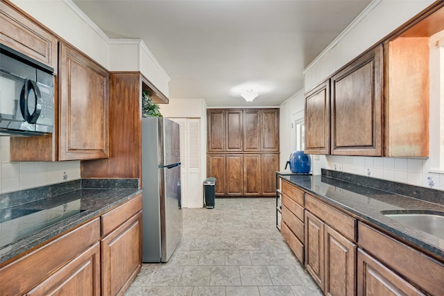 1719 W Day St, Denison, TX 75020 - kitchen featuring black appliances, tasteful backsplash, dark stone counters, and brown cabinets